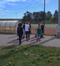 Dwie policjantki stoją przy skateparku na terenie Ośrodka Sportu i rozmawiają z grupą chłopców w wieku 12-15 lat.